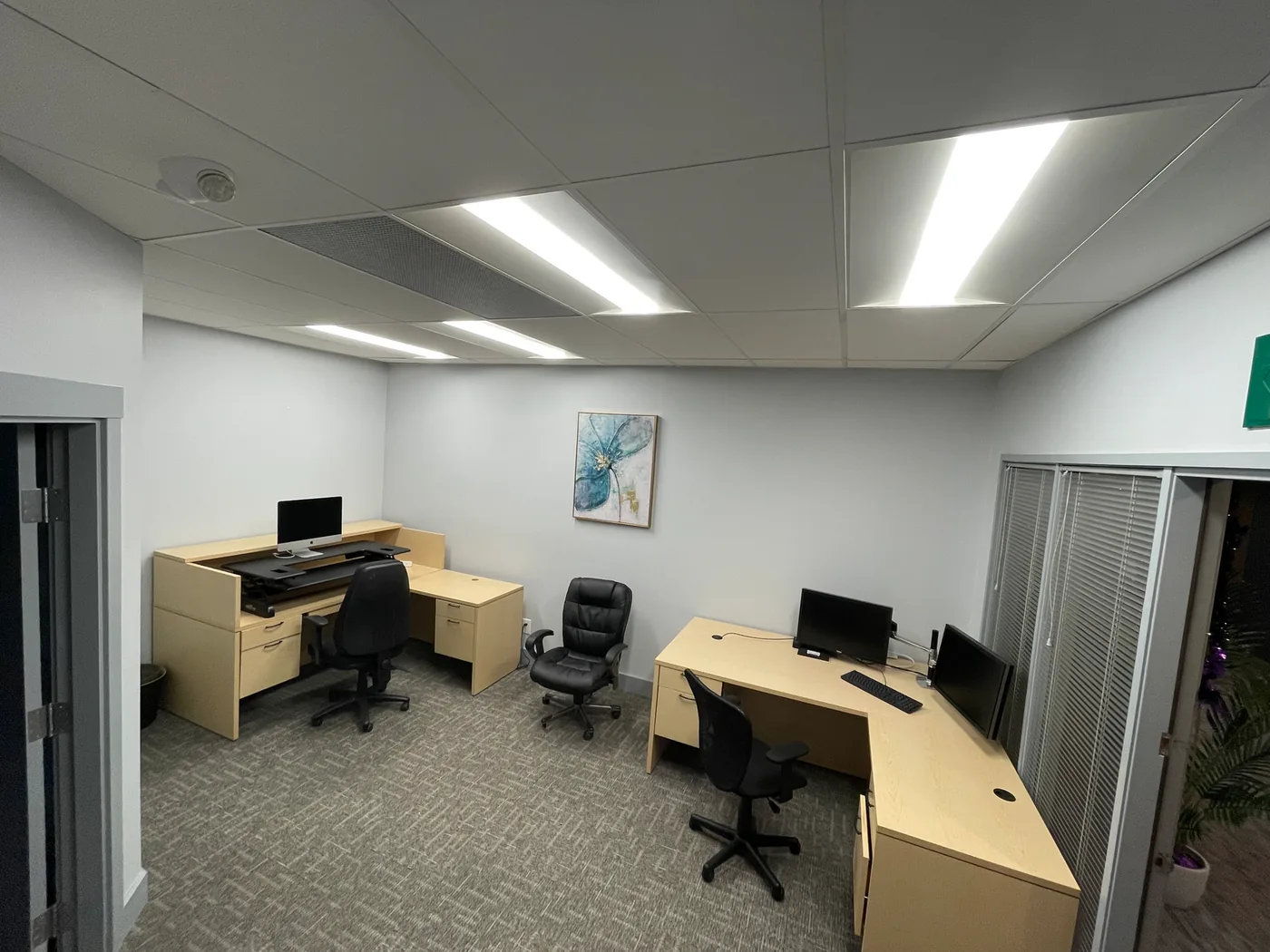 Shared office space with two desks, task chairs, and natural light